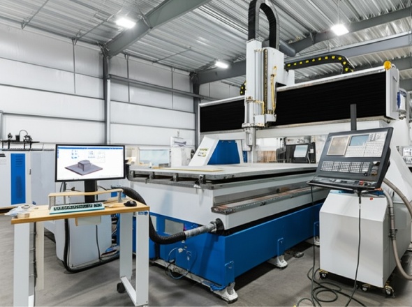 Industrial CNC machine processing large material sheet with precision tools