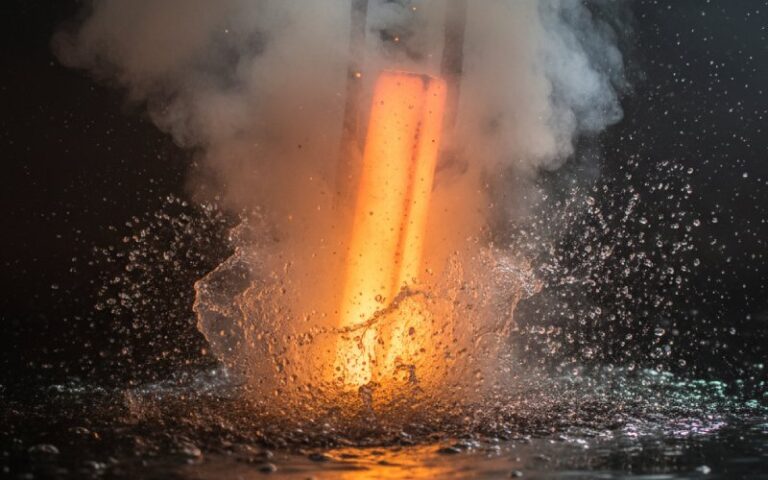 Glowing hot metal being quenched in water