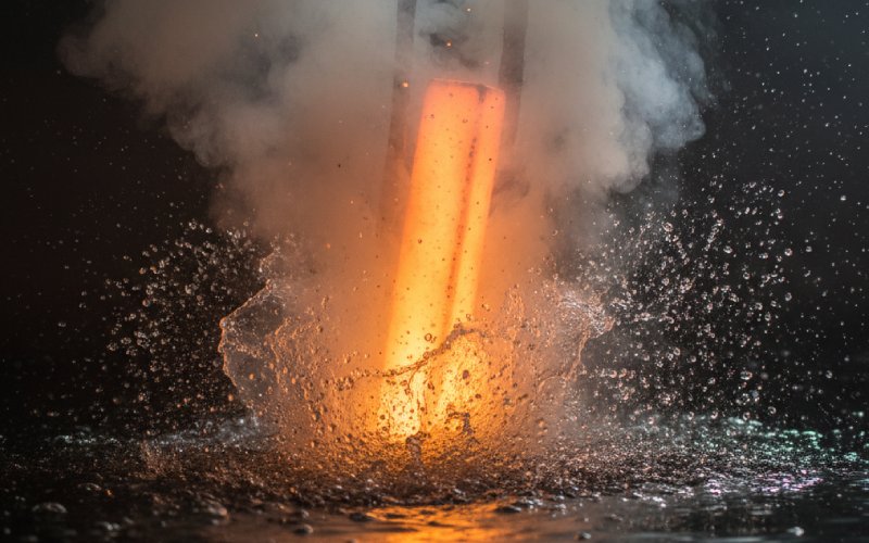 Glødende varmt metal bliver slukket i vand