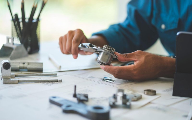 Engineer checking drawing and machined parts